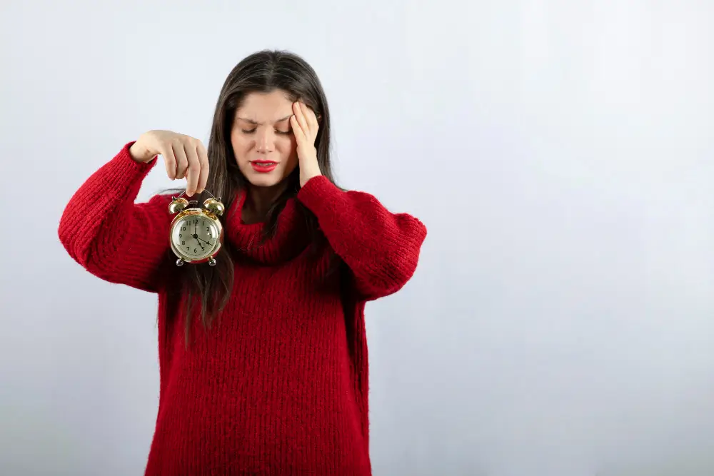 young beautiful brunette woman holding an alarm clock