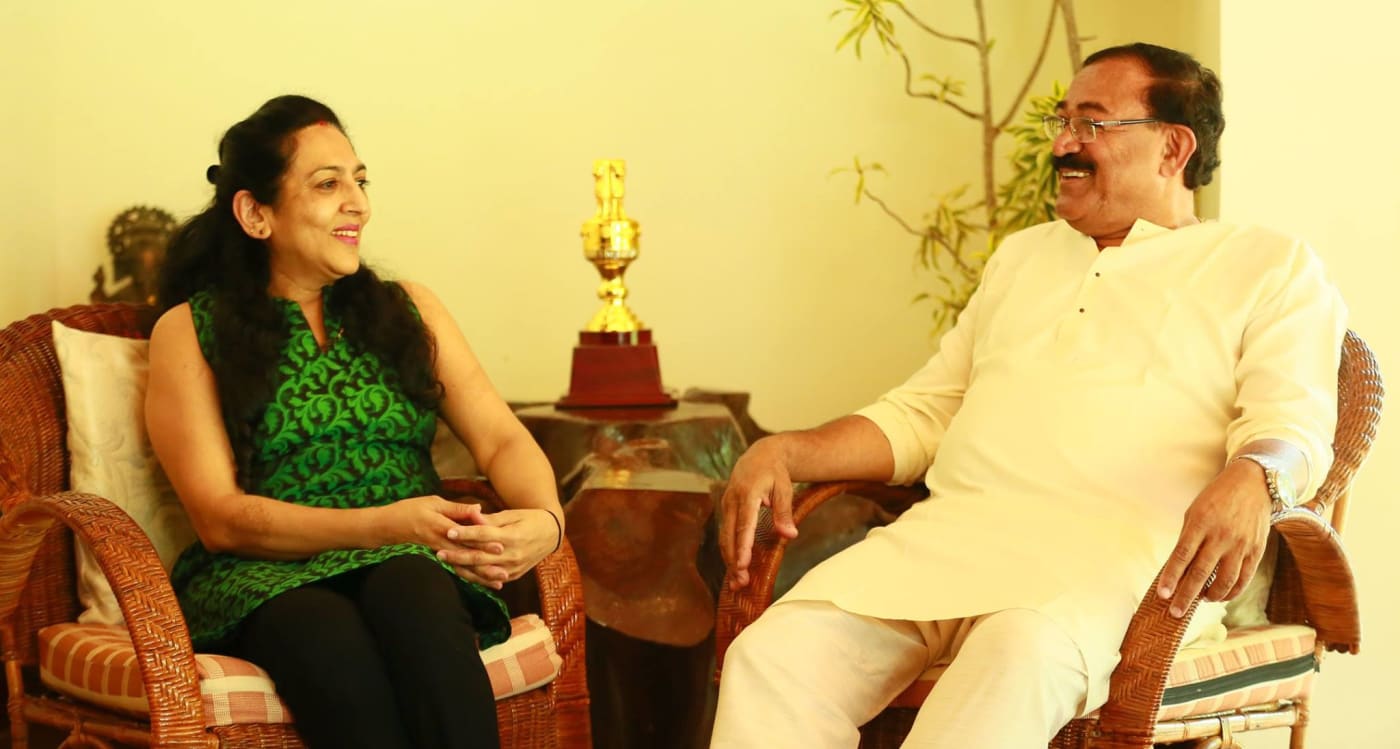 Arun Machaiah at home in conversation with his wife, a karate trophy on the table between them