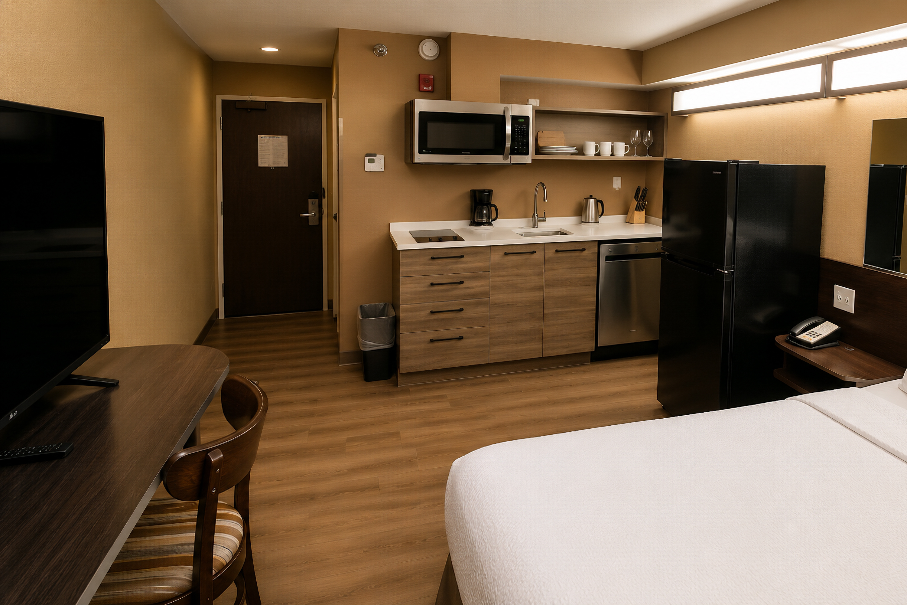 Microtel Williston Queen Kitchenette Suite bedroom with queen bed and work desk