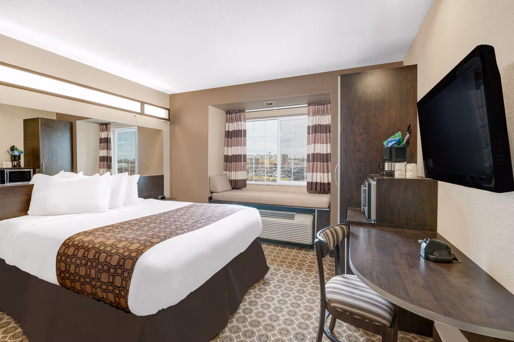 Microtel Williston standard queen room with queen bed, flat-screen TV and work desk