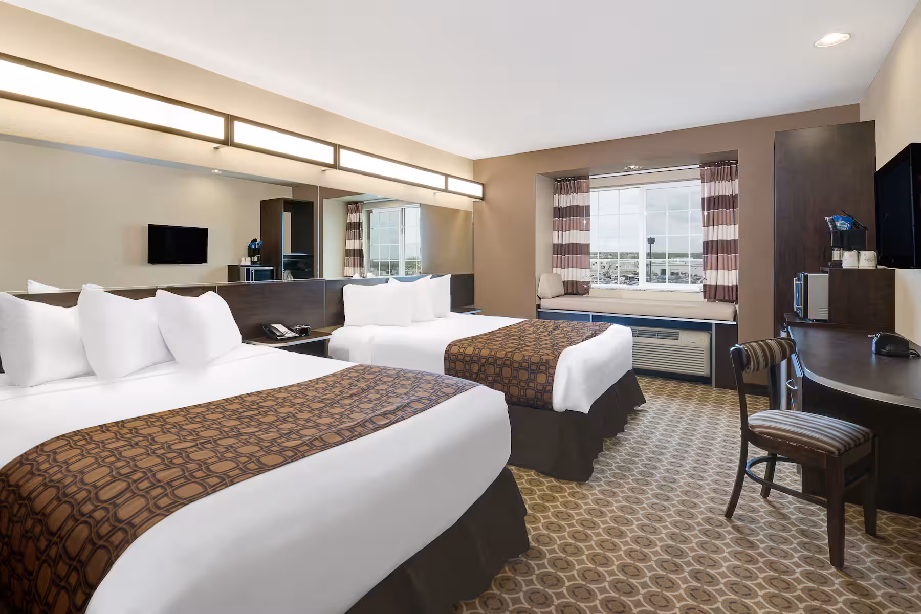 Microtel Williston double queen room with two queen beds, ideal for families