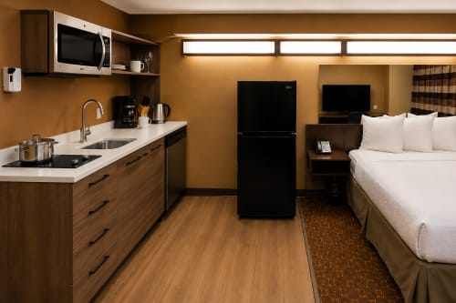 Microtel Williston kitchenette suite — induction cooktop in use with cookware, kettle and knife block