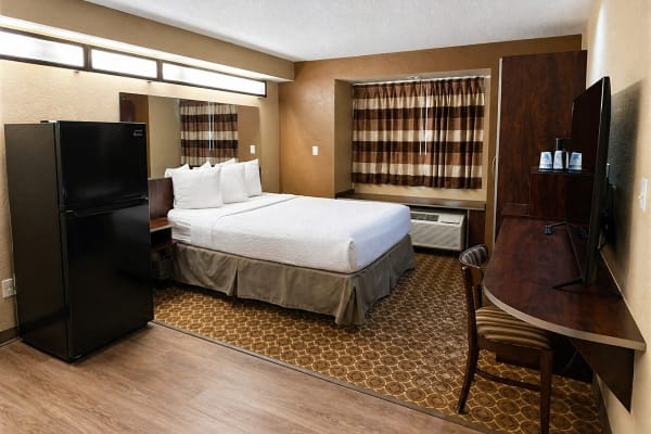 Queen bed and work desk in renovated suite