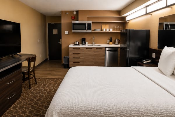 Full suite — queen bed, 65″ TV, work desk and complete kitchen