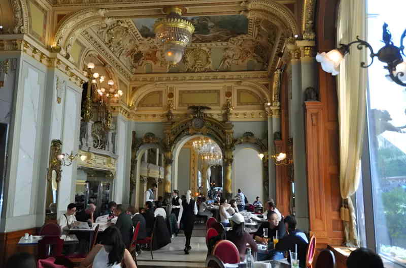 Elegant dining room at Hotel Grande, featuring ornate decor, polished tables, and soft lighting for a luxurious atmosphere.