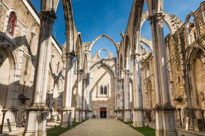 Interior view of a cathedral featuring tall arches and ornate pillars, showcasing intricate architectural details.