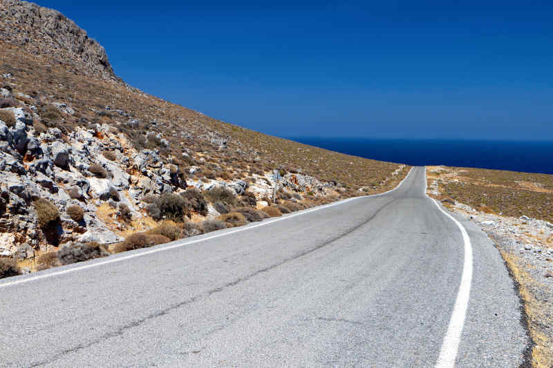 Road going off into the distance next to a mountain