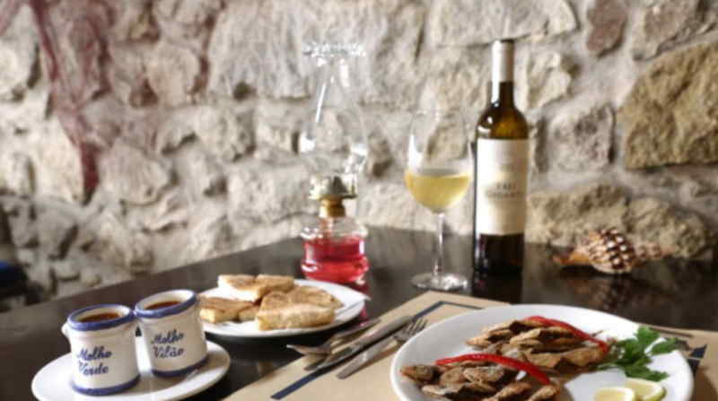 A beautifully set table featuring an array of food dishes and a bottle of wine, ready for a meal.