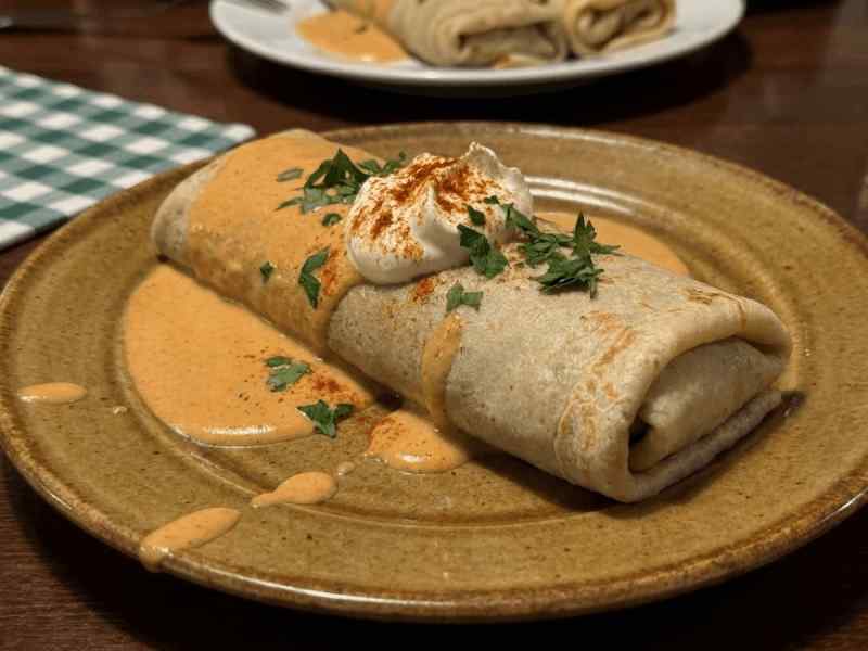 Meat-filled Hungarian crepe served in a creamy paprika sauce, topped with sour cream