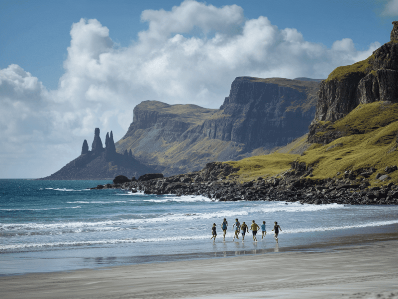 Group of people walking along Talisker Bay Beach on the Isle of Skye, Scotland, with dramatic cliffs, sea stacks in the distance, and turquoise waves rolling onto the sandy shore