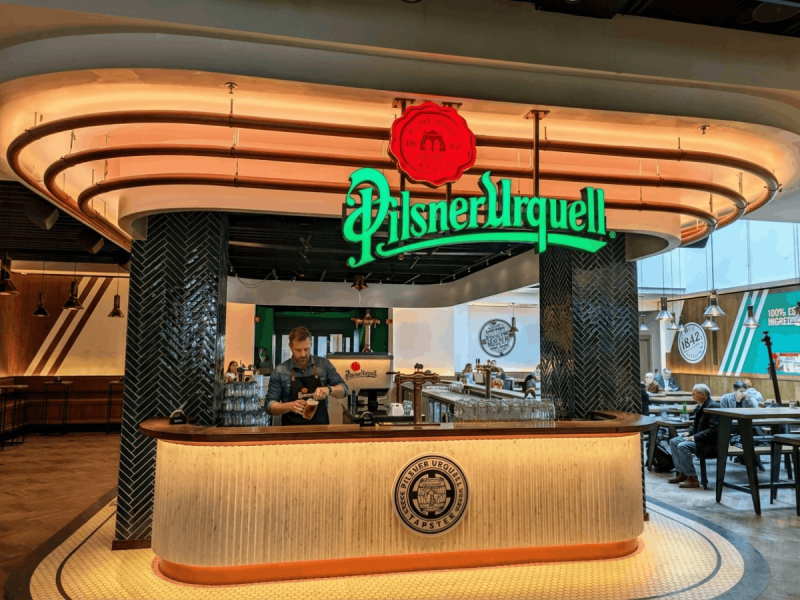 Bartender pouring a fresh Pilsner Urquell at a dedicated bar, one of the best Czech beers.