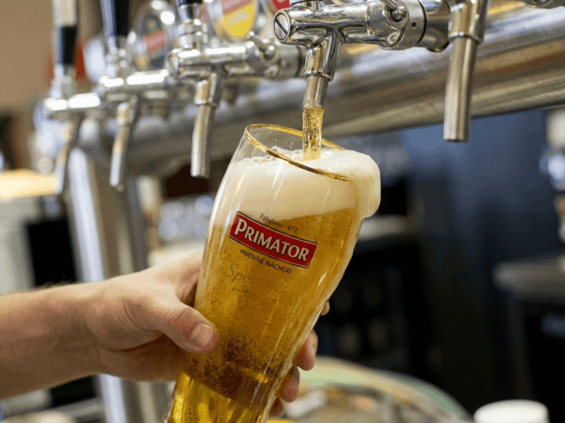 Bartender pouring a fresh Primátor Weizenbier from the tap, one of the best Czech beers.