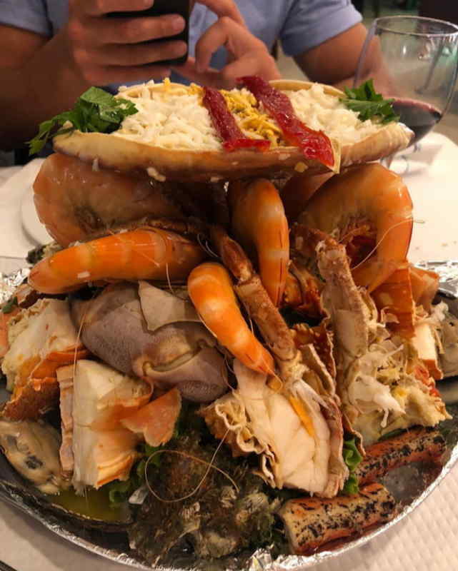 A beautifully arranged seafood platter featuring shrimp, crab, and fish on a table setting.