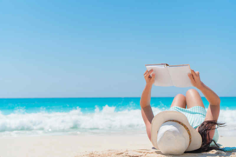 Woman reading on tropical beach