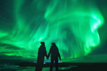 Couple gazing at the Aurora borealis