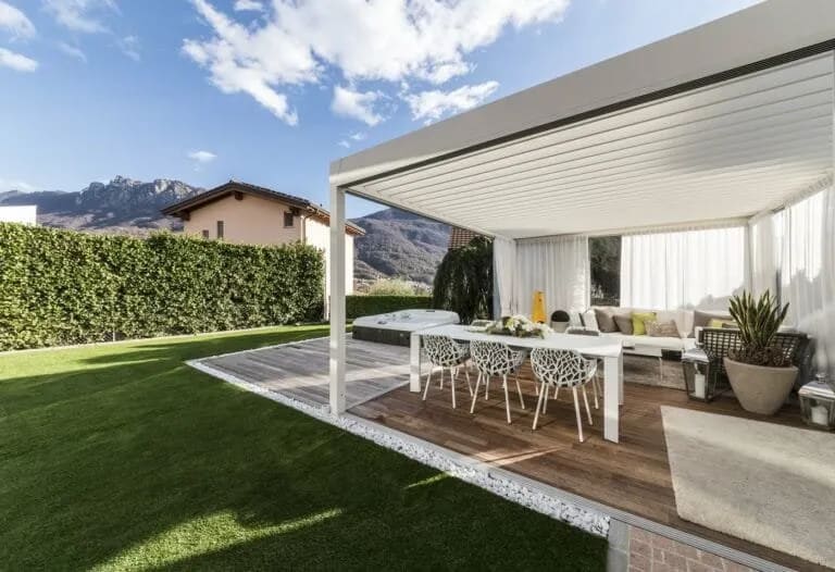 Salle à manger extérieure installée sous une pergola en bois pour des repas conviviaux en plein air.