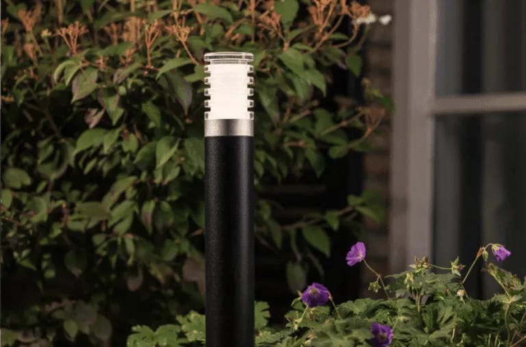 Potelets lumineux modernes balisant le chemin et les abords d'une terrasse en bois exotique.
