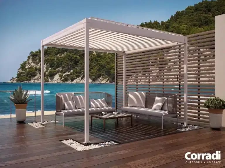 Pergola en bois décorée de guirlandes lumineuses au-dessus d'un salon de jardin cosy.