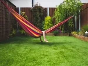 Contraste entre les lames de bois clair et la pelouse artificielle d'un aménagement extérieur.