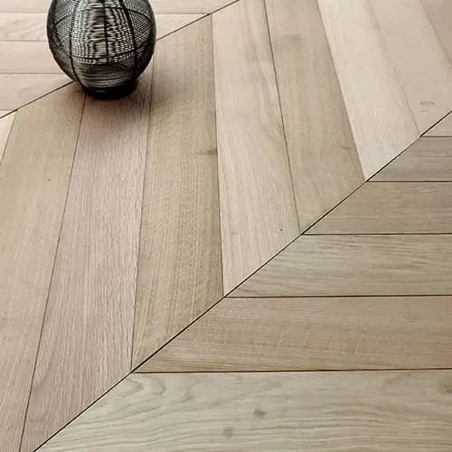 Sol en bois massif posé en point de Hongrie avec des motifs en chevrons élégants.