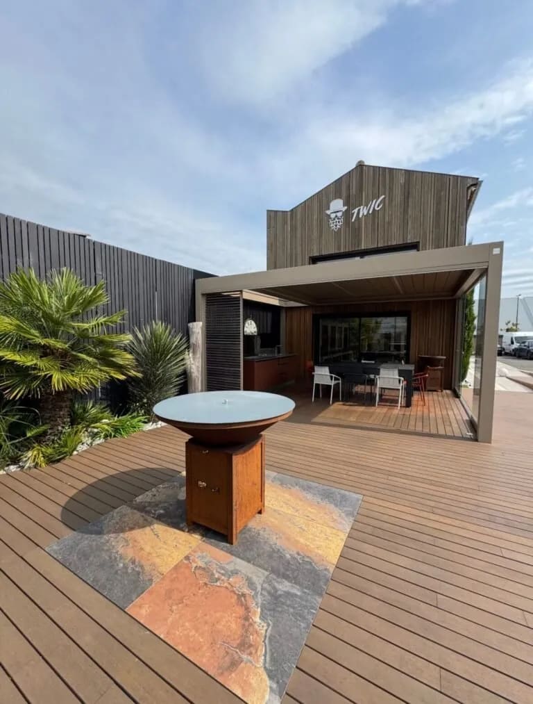 Brasero de jardin crépitant sur une terrasse en bois composite lors d'une soirée conviviale.