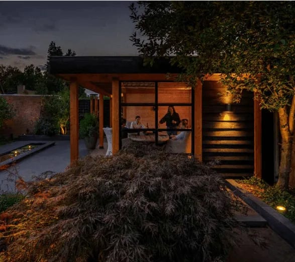 Ensemble de luminaires LED variés créant une ambiance chaleureuse sur une terrasse en bois clair.