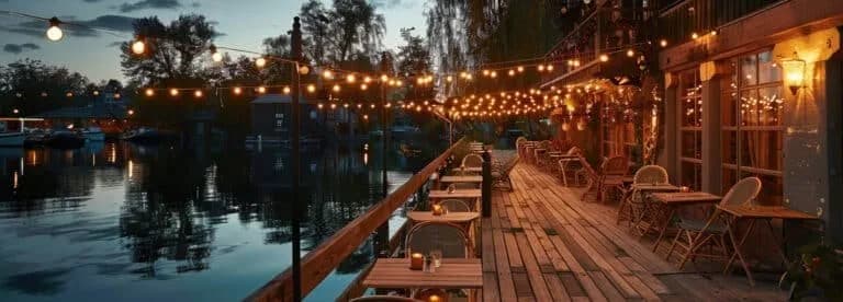 Terrasse en bois illuminée par des guirlandes et des lanternes pour une soirée conviviale.