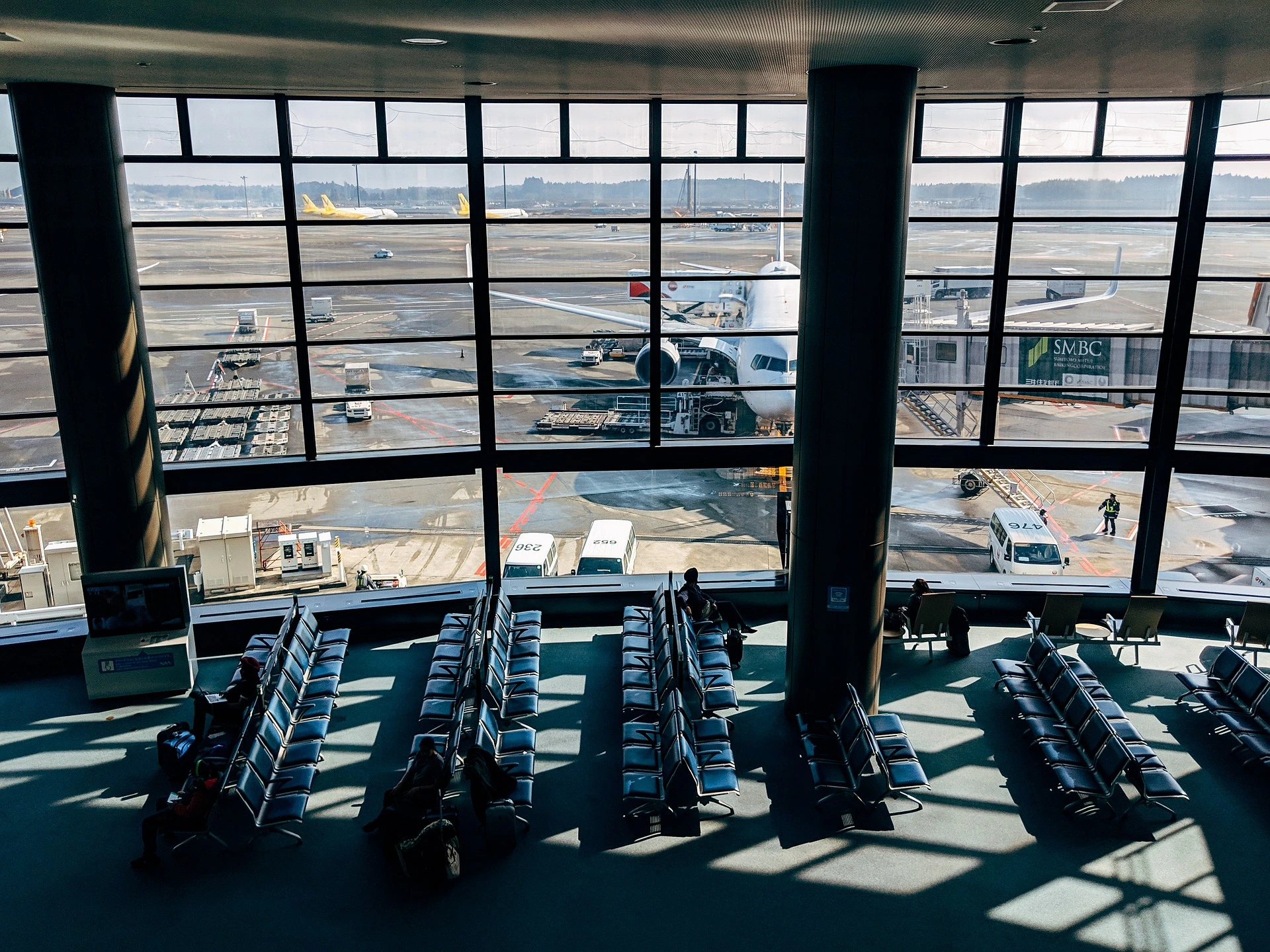 Travellers with luggage in an arrivals hall — a flight-tracked pickup already waiting for Docklands