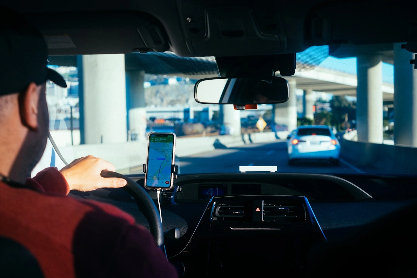 Driver navigating with GPS on a Melbourne freeway, flight-tracked airport pickup