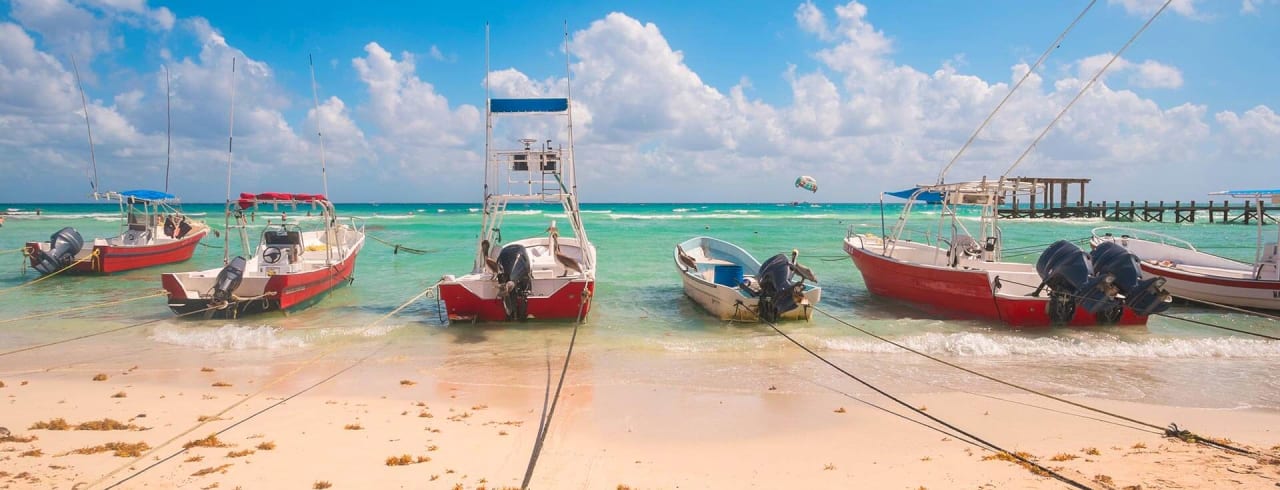 Barcos de pescadores ancorados na costa de Playa del Carmen