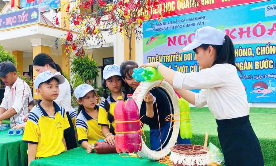 Học sinh được hướng dẫn thực hành kỹ năng an toàn dưới nước và sử dụng các vật dụng hỗ trợ cứu hộ - Ảnh: M.H