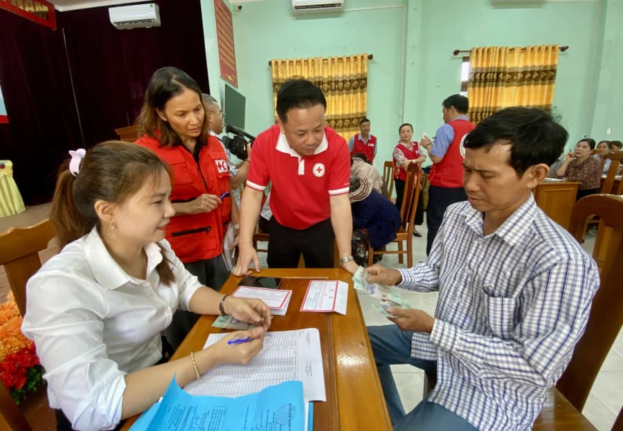 Cấp phát tiền mặt cho các hộ gia đình hưởng lợi từ dự án - Ảnh: H.N