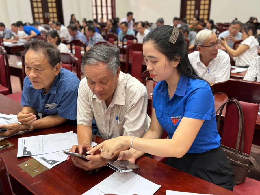 Tổ thanh niên số phường Nam Đông Hà hỗ trợ đảng viên cài đặt Sổ tay đảng viên điện tử - Ảnh: H.V