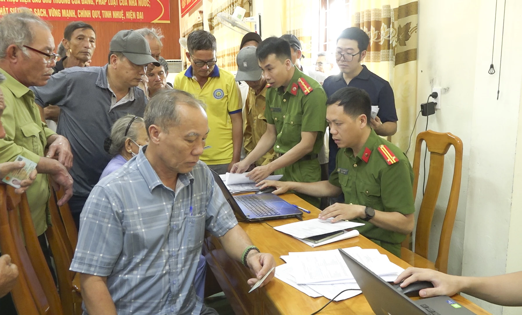 Cán bộ Công an hỗ trợ thân nhân liệt sĩ trong quy trình thu nhận mẫu ADN. Ảnh: N.Q.V