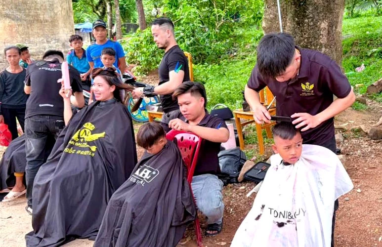 Các đoàn viên thanh niên chăm sóc sức khỏe, cắt tóc cho các em nhỏ ở bản Tân Ly - Ảnh: P.V