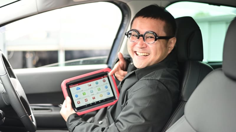 輸入車用の診断機を手にするスタッフ