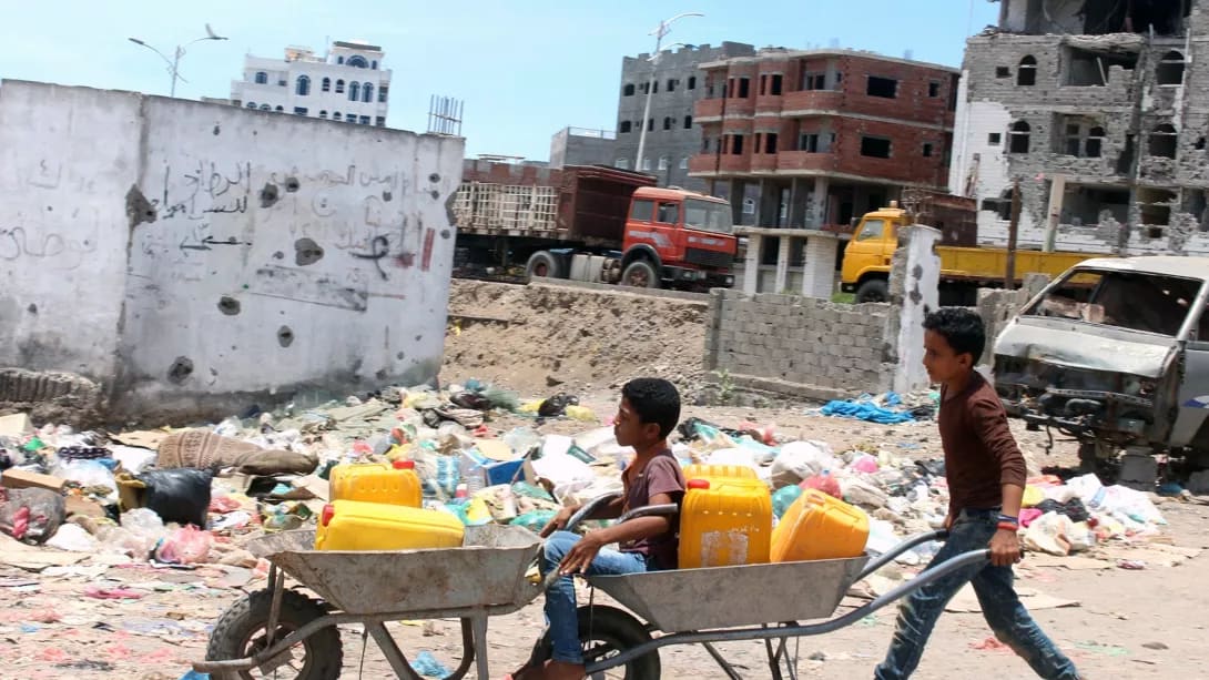 Children return home after filling their jerrycans with water amid a severe shortage of water in the city of Aden, on April 30, 2020