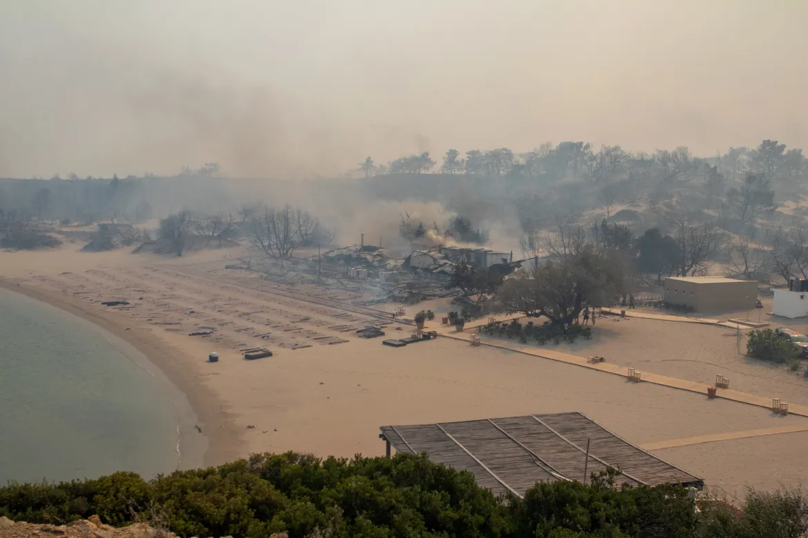 A wildfire burns next to a beach near Lindos. Local media reported the fires reached three hotels, whose clients had already been evacuated.