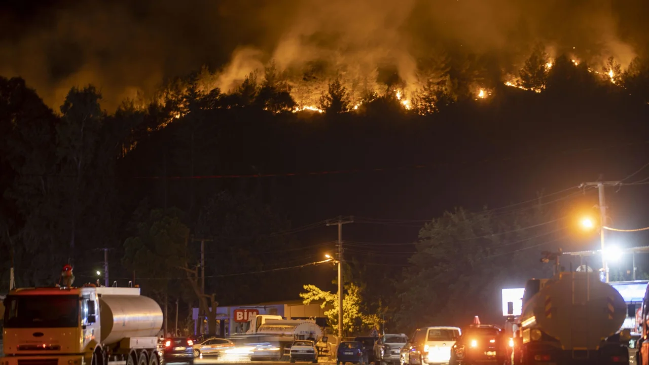 Smoke and flames rise as firefighters battle a blaze by air and land in Marmaris, Turkey,