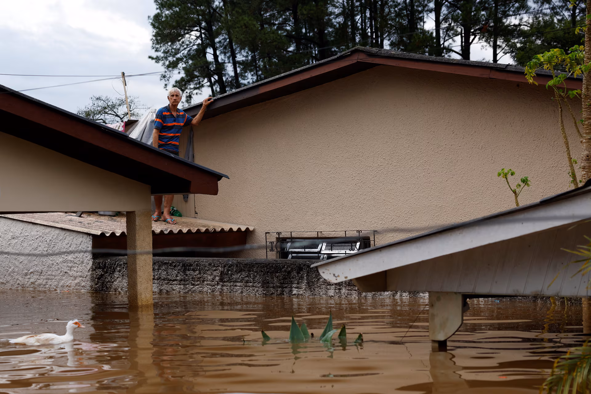 Julio Manichesque, 76 years old, stands on the roof of his house after floods in Canoas, at the Rio Grande do Sul state, Brazil, May 5