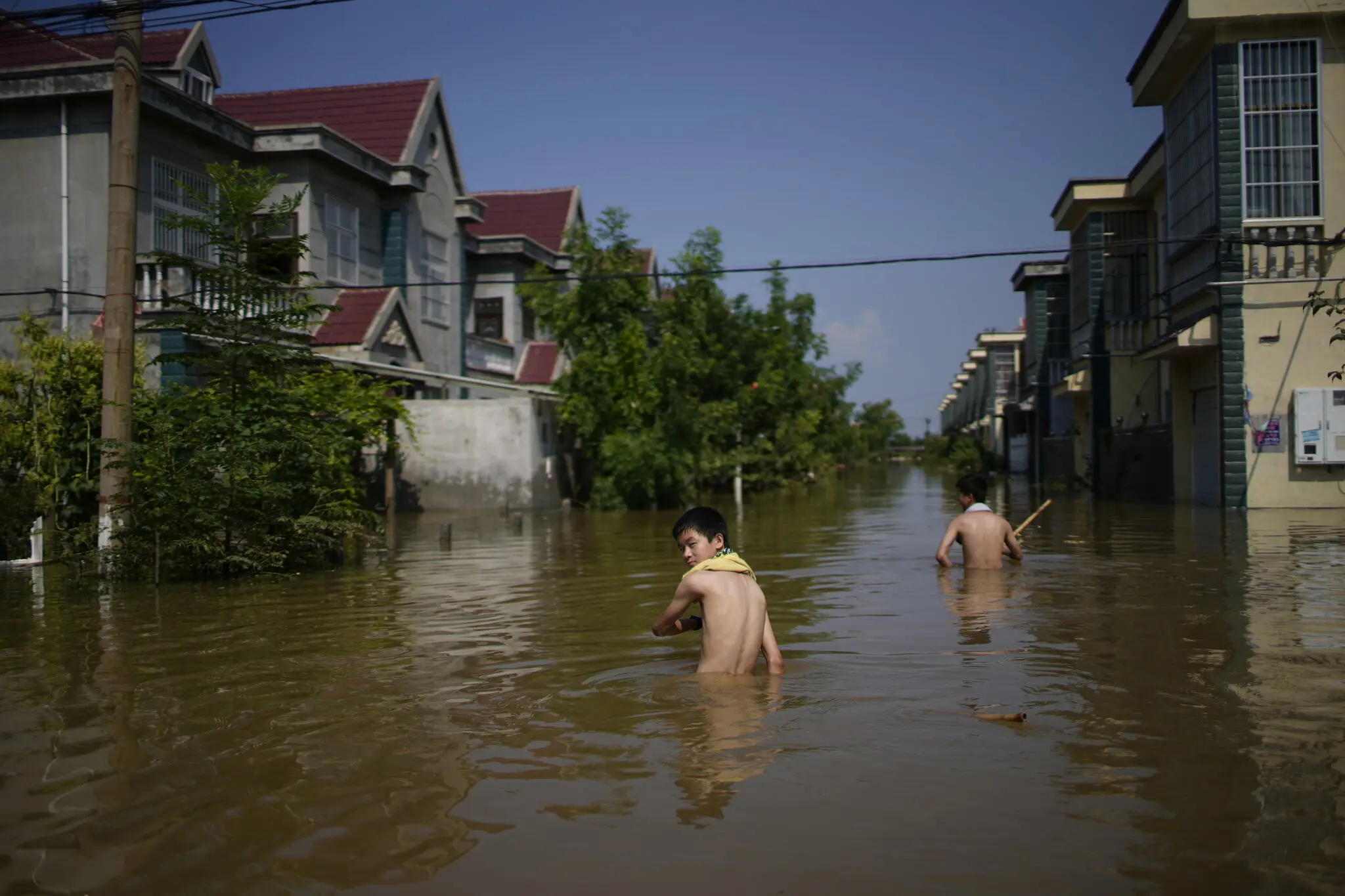 Children wading through floodwaters in Xinxiang, a town in central China, Apr 22, 2024.