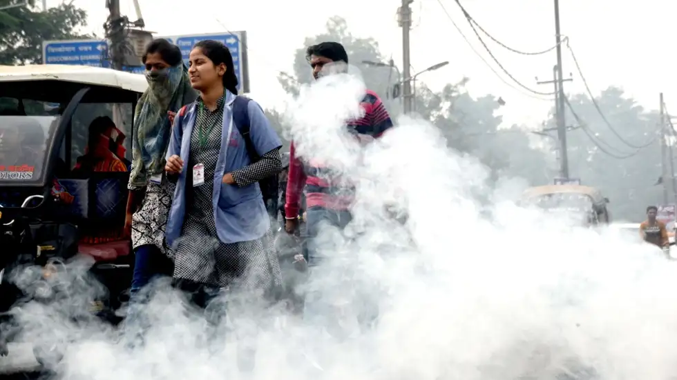 People passing by heavy smoke in Patna.