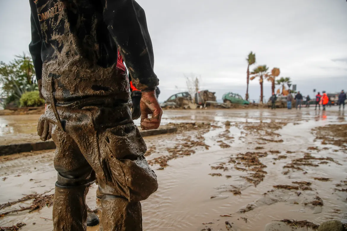 Rescuers work to remove mud along the sea front on the island of Ischia after heavy rains caused landslides. [Salvatore Laporta/AP Photo]