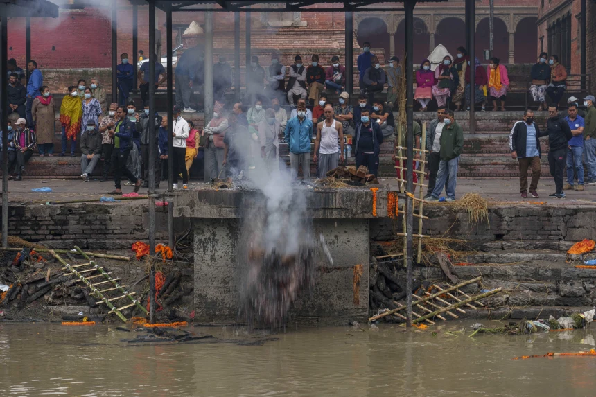 A man pushes cremated remains into the Bagmati River at the Pashupatinath Temple in Kathmandu in May.