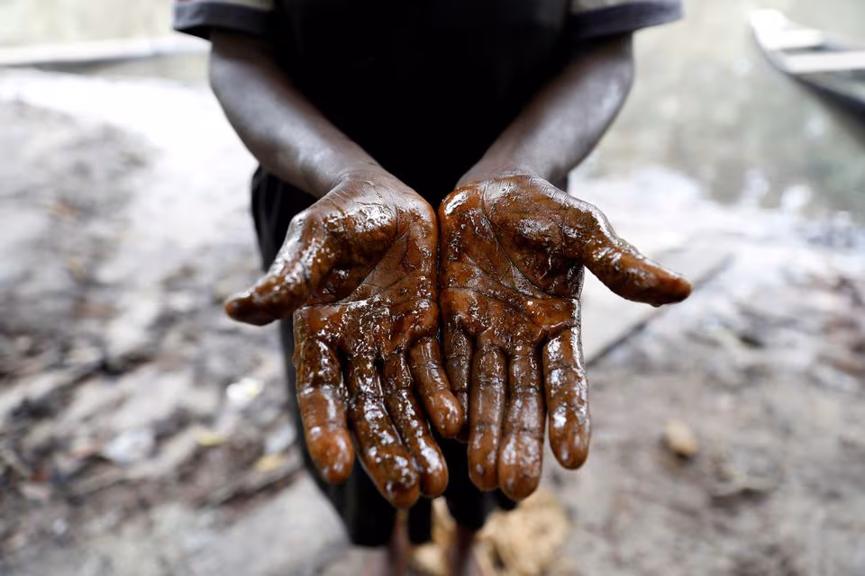 Afieyegha Seiyefa, a fisherwoman shows her hands stained by oil, following an oil spill at Santa Barbara in Nembe, in Bayelsa, Nigeria, November 25, 2021.
