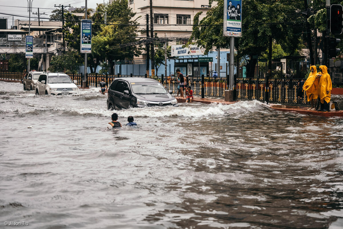 People cross the streets of Espana, Manila, after the Philippine capital was submerged by flood at the height of typhoon Ulysses (Vamco) in November 2020.