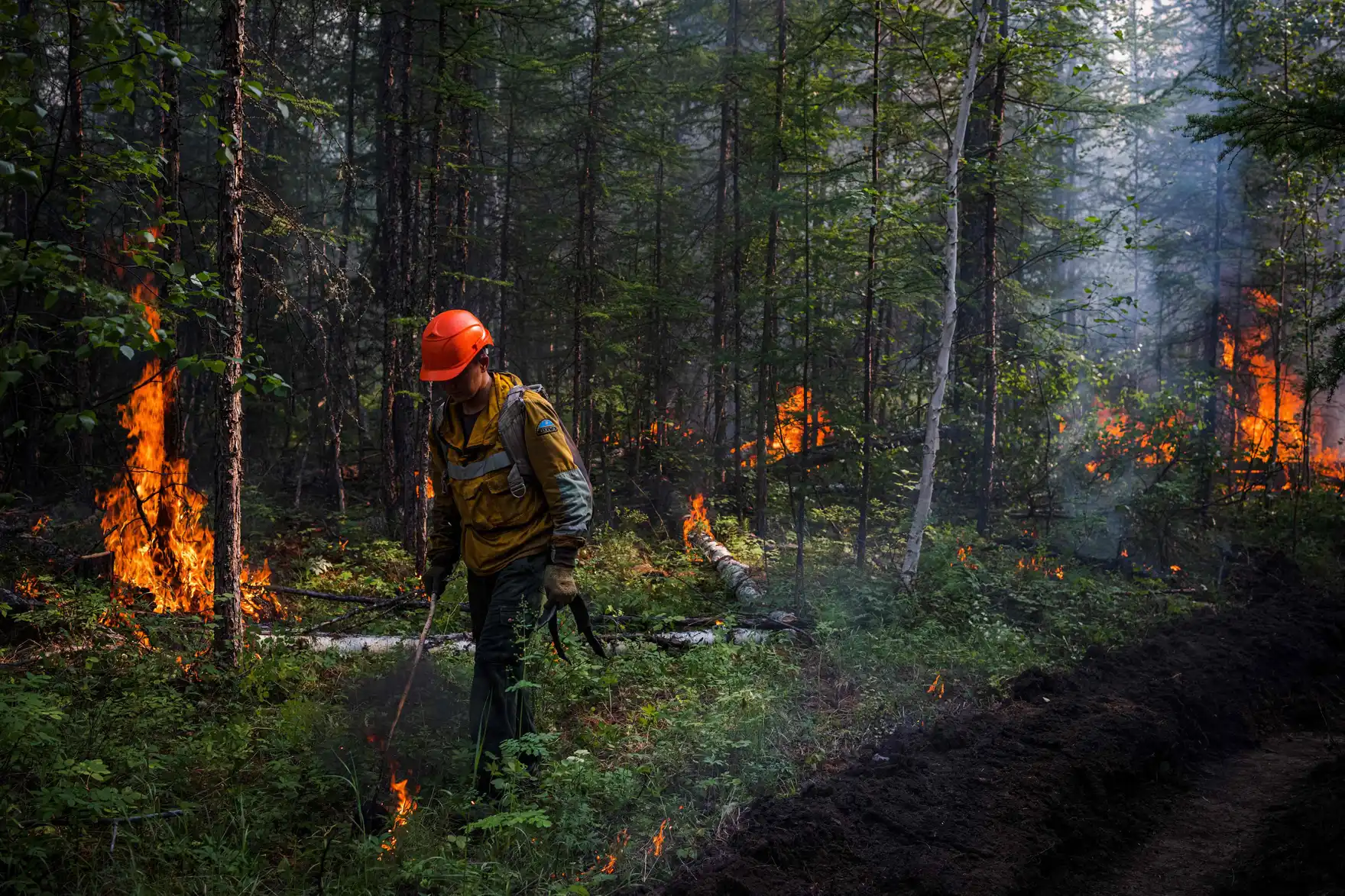 Wearing respirators against the acrid smoke, AFPS members start a controlled burn