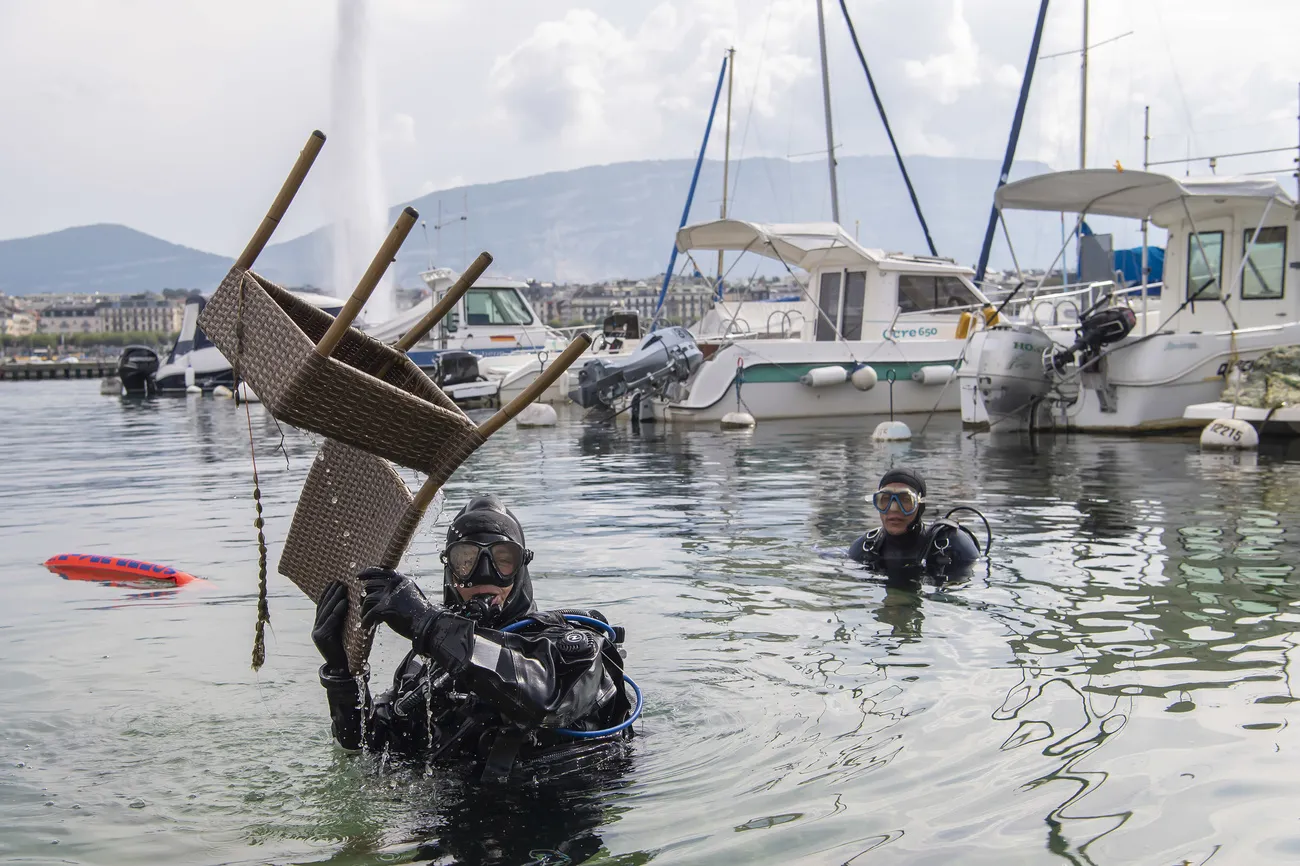 A diver pulls a chair out of Lake Geneva