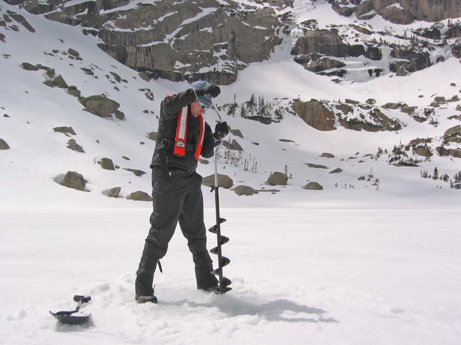 Researcher cores through the ice to obtain water samples from the Loch. These samples are used to measure lake chemistry in the water