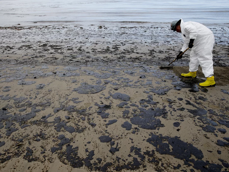 A worker removes oil at California's Refugio State Beach on May 21, 2015.